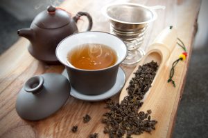 Fresh cup of oolong tea Teapot, cup of oolong tea, and oolong tea leaves
